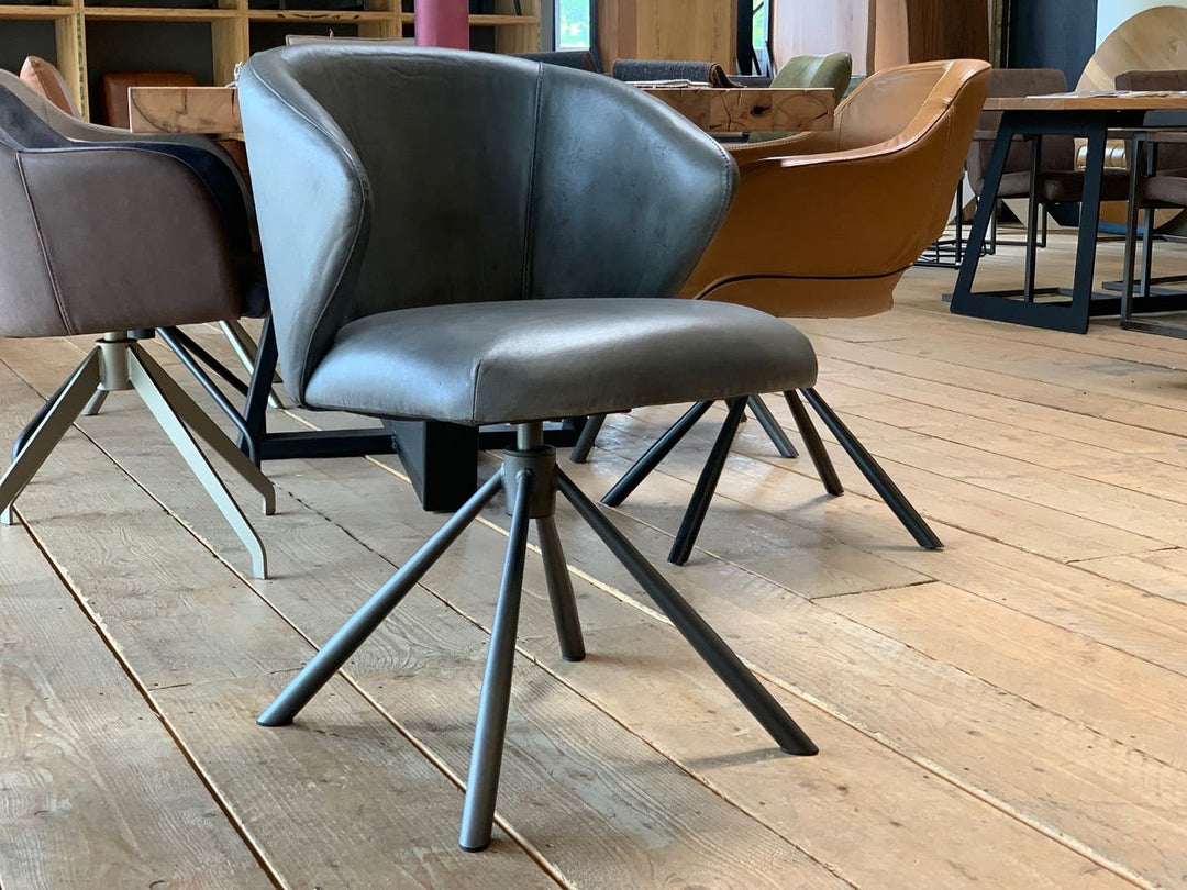 Drehbarer Schalenstuhl aus Leder mit ergonomischer Form, weicher Polsterung und modernem Metallgestell im stilvollen Esszimmer.