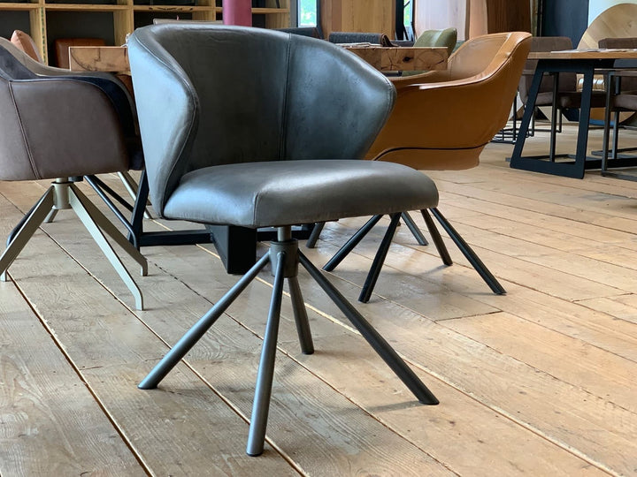 Drehbarer Schalenstuhl aus Leder mit ergonomischer Form, weicher Polsterung und modernem Metallgestell im stilvollen Esszimmer.