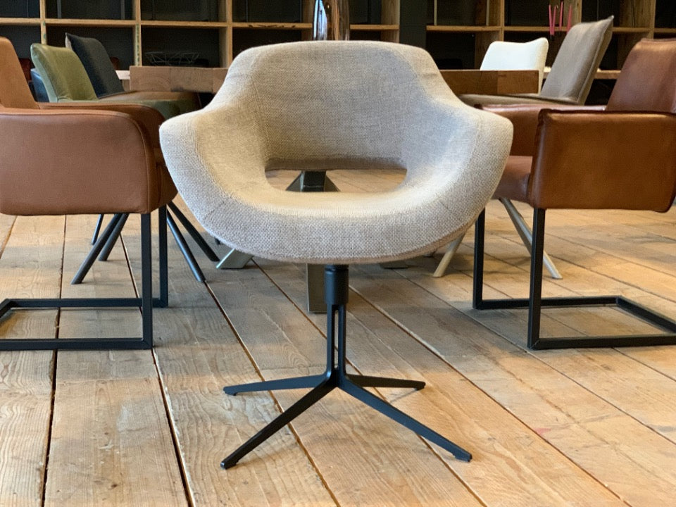 Vorderansicht eines modernen Schalenstuhls mit beigem Stoffbezug und Drehfunktion, Esszimmerstuhl mit offener Rückenform und schwarzem Metallgestell