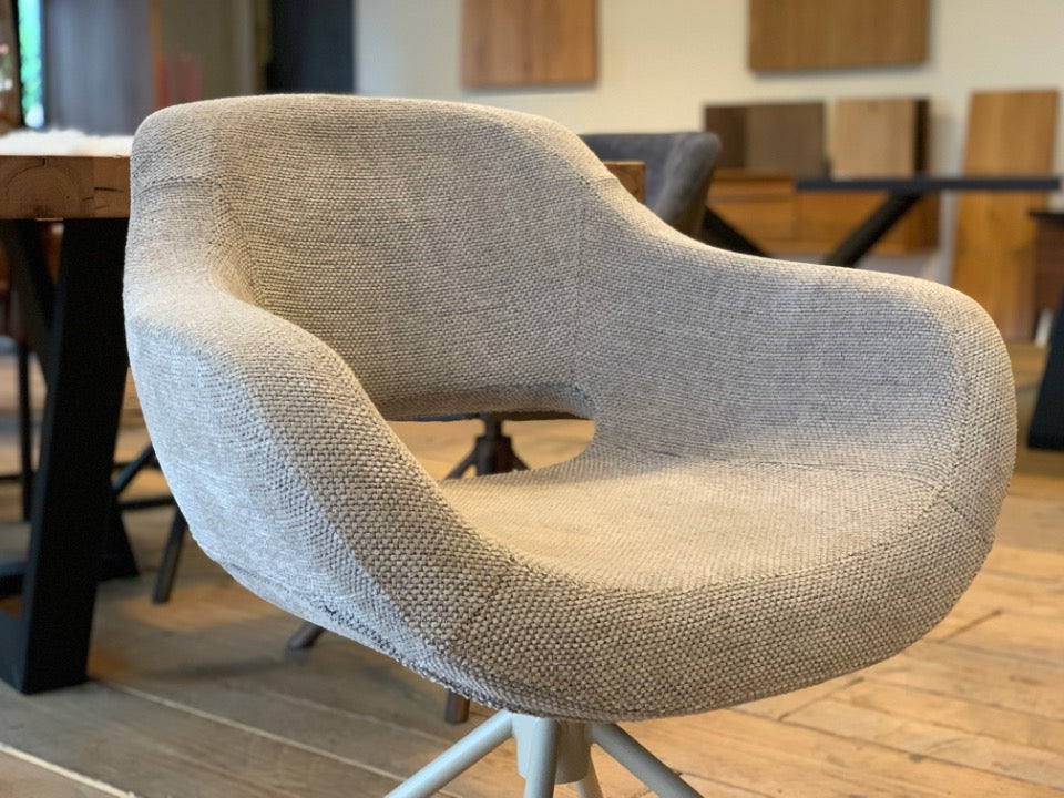 Detailansicht der Sitzschale eines modernen Schalenstuhls mit Drehfunktion und beigem Stoffbezug, ergonomisch geformte Sitzfläche