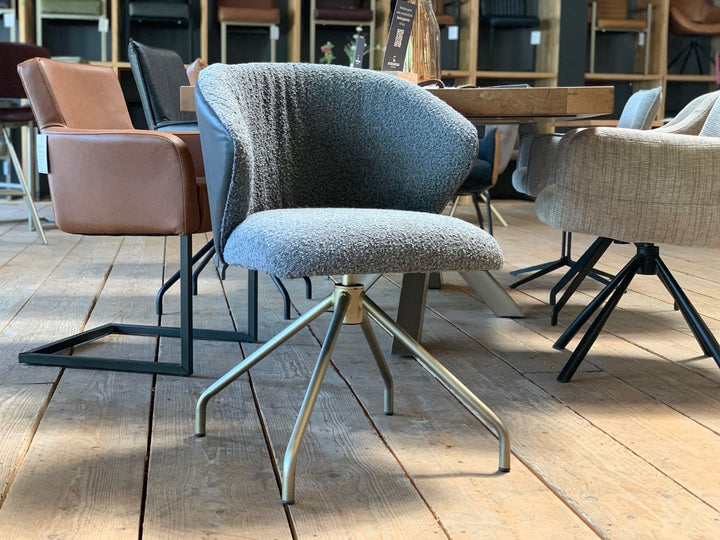Moderner Stuhl mit Leder-Stoff-Kombination, gepolsterte Sitzschale mit strukturierter Stoffoberfläche und glatter Leder-Rückseite, drehbares Metallgestell im Esszimmer