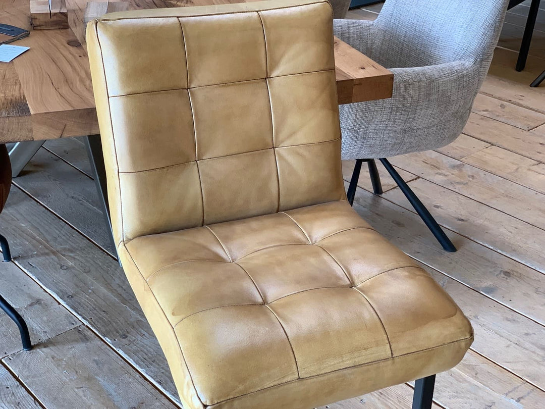 Thekenstuhl Leder Industrial in Mustard Detail: Nahaufnahme der gepolsterten Sitz- und Rückenfläche aus senfgelbem Leder mit markanter Steppung, die die hochwertige Verarbeitung im Industrial-Stil hervorhebt.